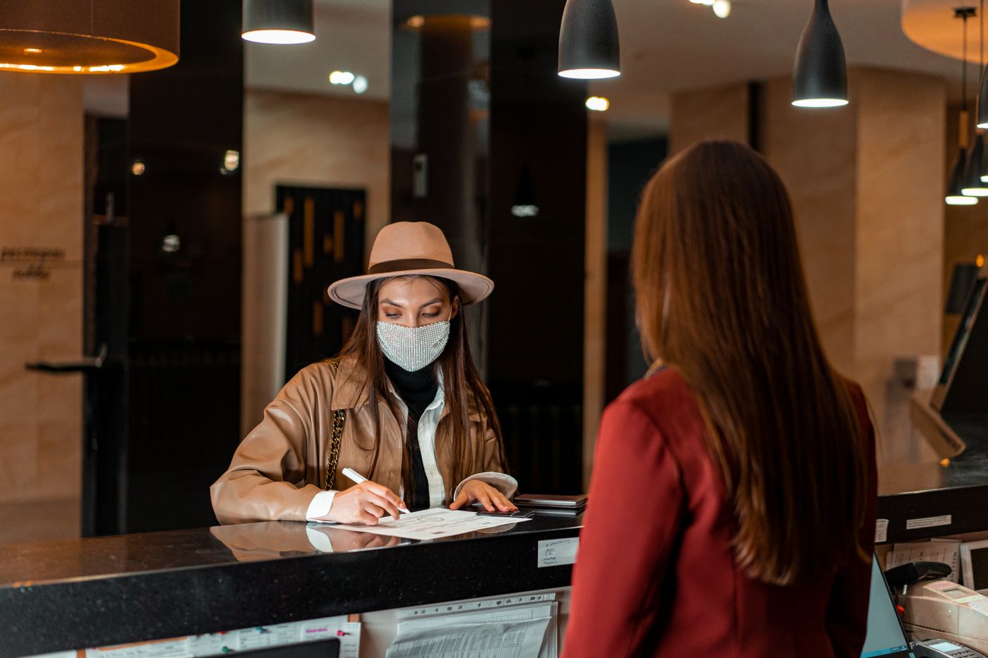 A visitor signing in at a reception desk