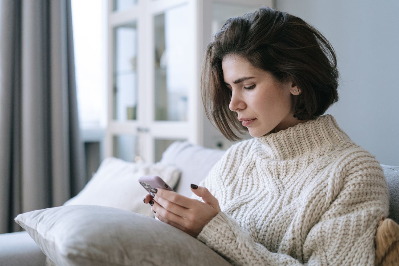 A resident using a phone on a sofa at home