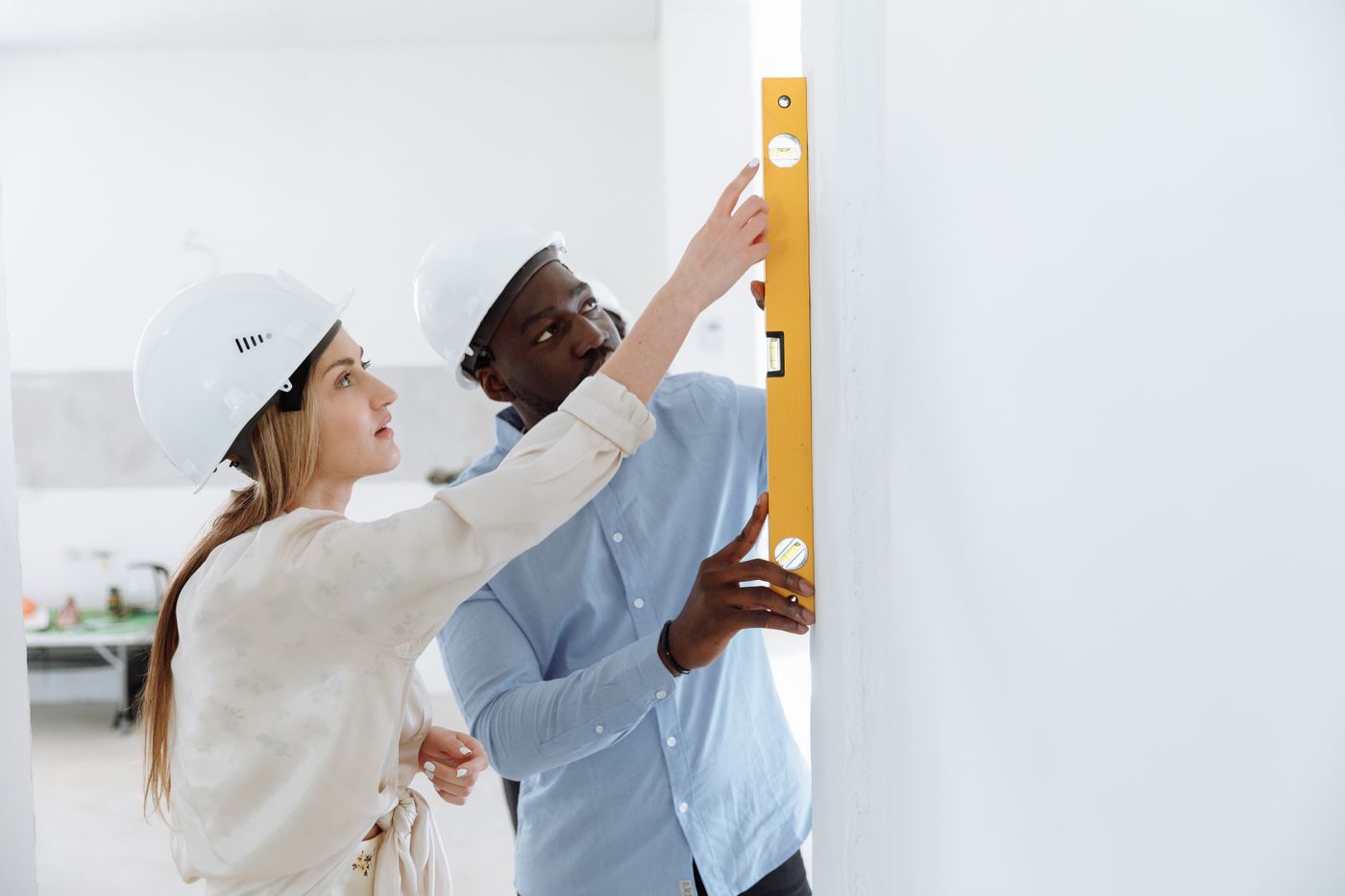 An inspector and a buyer checking a wall in a new unit
